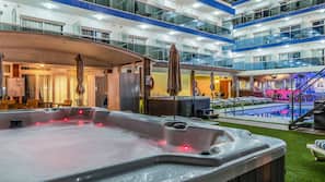 Una piscina al aire libre, sombrillas, tumbonas