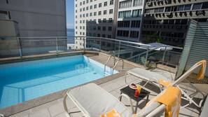 Una piscina al aire libre, sombrillas
