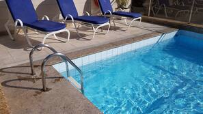 Una piscina al aire libre, sombrillas