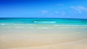 Am Strand, weißer Sandstrand, Liegestühle, Sonnenschirme