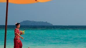 On the beach, white sand, beach umbrellas, beach towels