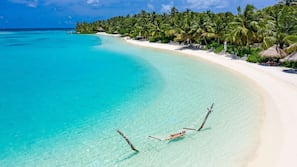 sheraton maldives spa moon resort beach umbrellas loungers sand private sun