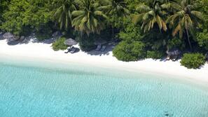On the beach, white sand, sun-loungers, beach umbrellas