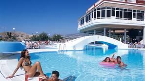 Una piscina al aire libre, sombrillas, tumbonas
