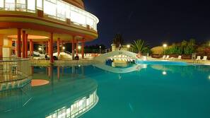 Una piscina al aire libre, sombrillas, tumbonas