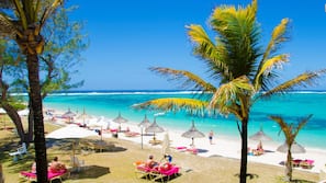 On the beach, white sand, sun loungers, beach umbrellas