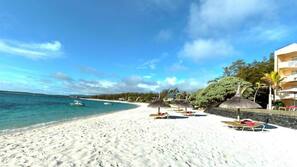 On the beach, white sand, sun loungers, beach umbrellas