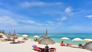 On the beach, white sand, sun loungers, beach umbrellas
