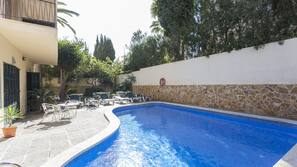Una piscina al aire libre, tumbonas