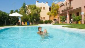 Una piscina al aire libre, tumbonas