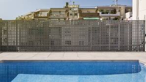 Una piscina al aire libre de temporada, tumbonas