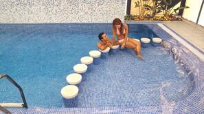 Una piscina al aire libre, sombrillas, tumbonas
