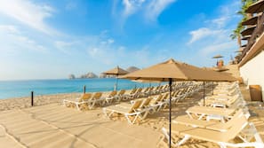 On the beach, white sand, sun loungers, beach umbrellas