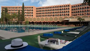 Una piscina al aire libre, sombrillas, tumbonas
