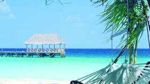 Plage, sable blanc, chaises longues, parasols
