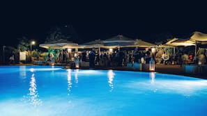 Una piscina al aire libre, sombrillas, tumbonas