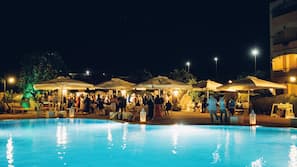 Una piscina al aire libre, sombrillas, tumbonas
