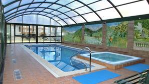 Una piscina cubierta, sombrillas, tumbonas