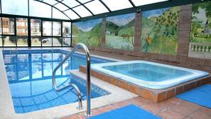 Una piscina cubierta, sombrillas, tumbonas