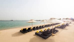 On the beach, white sand, sun-loungers, beach bar