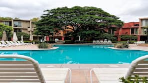 Una piscina al aire libre, sombrillas, tumbonas