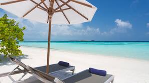 Beach nearby, white sand, beach towels, windsurfing