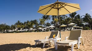Am Strand, weißer Sandstrand, Sonnenschirme, Strandtücher