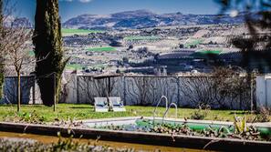 Una piscina al aire libre, sombrillas, tumbonas