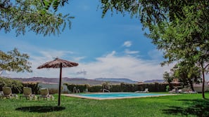 Una piscina al aire libre, sombrillas, tumbonas
