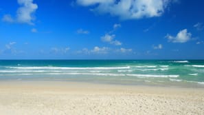 On the beach, white sand, sun loungers, beach umbrellas