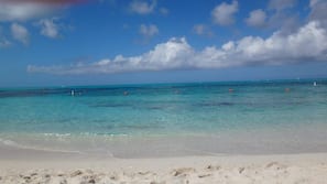 On the beach, white sand, sun loungers, beach umbrellas