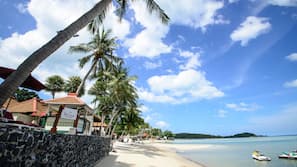 On the beach, white sand, sun-loungers, beach umbrellas
