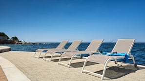 On the beach, sun-loungers, beach umbrellas, beach bar