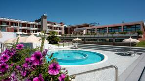 Piscine couverte, piscine extérieure, parasols de plage, chaises longues