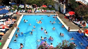 Una piscina al aire libre de temporada, sombrillas, tumbonas