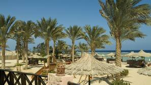 Plage privée, sable blanc, parasols, serviettes de plage