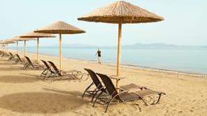 On the beach, black sand, sun-loungers, beach umbrellas