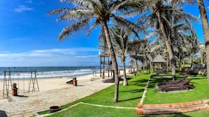 Am Strand, weißer Sandstrand, Liegestühle, Sonnenschirme