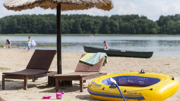 En privat strand, liggestole, parasoller, volleyball