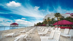 On the beach, white sand, sun-loungers, beach towels