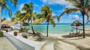 On the beach, white sand, sun-loungers, beach towels