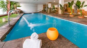 Una piscina al aire libre, sombrillas, tumbonas