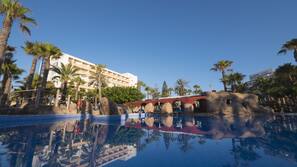 Una piscina al aire libre, sombrillas, tumbonas