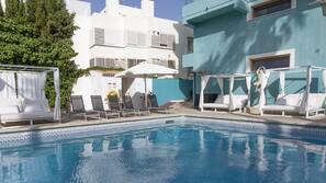 Una piscina al aire libre, tumbonas