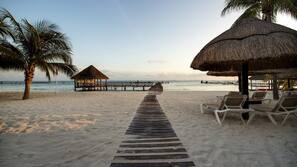 On the beach, white sand, sun-loungers, beach umbrellas