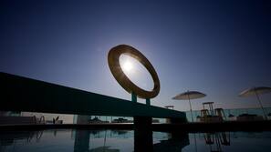 Una piscina al aire libre, sombrillas, tumbonas