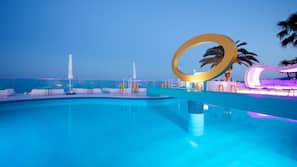 Una piscina al aire libre, sombrillas, tumbonas