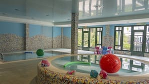 Una piscina cubierta, una piscina al aire libre, sombrillas, tumbonas