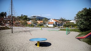På stranden, solsenger, strandhåndklær og sandvolleyball