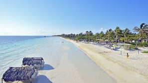 On the beach, white sand, sun-loungers, beach umbrellas